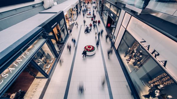 Imagem que mostra o espaço de um shopping, com várias marcas | Bárions Produções